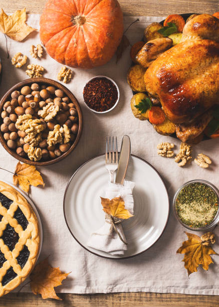 istock Fall thanksgiving table with roasting chicken or turkey, nuts, pie, pumkins and other food on light 1278655433