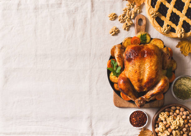 istock Fall thanksgiving table with roasting chicken or turkey, nuts, pie, pumkins and other food on light tablecloth 1278655437