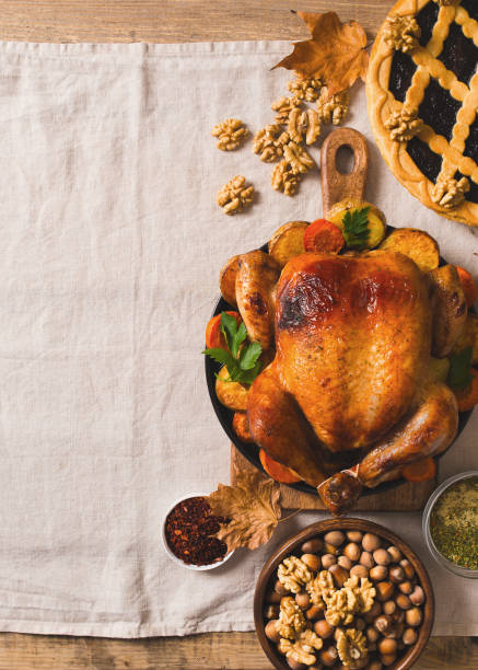 istock Fall thanksgiving table with roasting chicken or turkey, nuts, pie, pumkins and other food on light tablecloth 1278655449