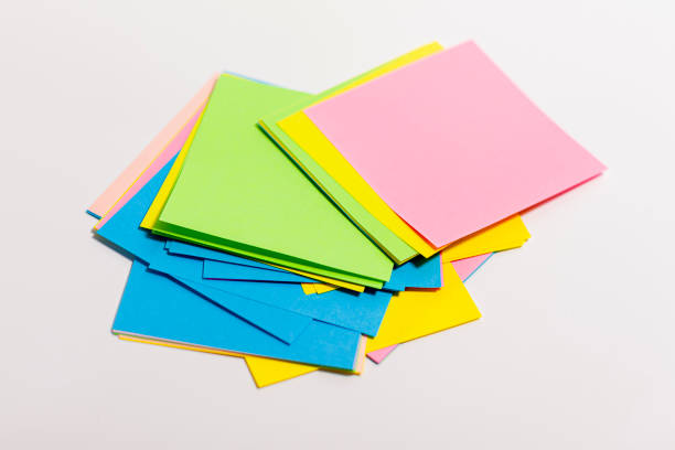 istock Sheets of paper of different colors are arranged in a column on a white surface. 1278657452