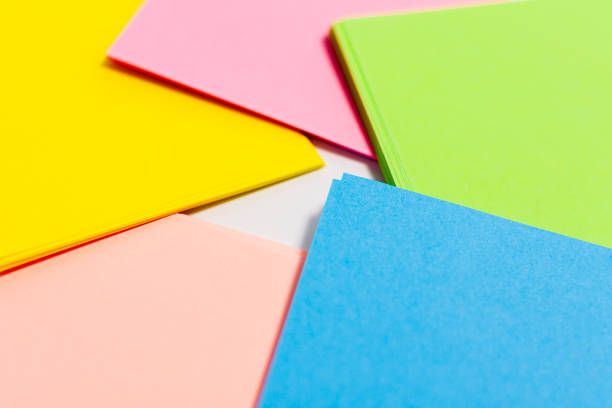 istock Sheets of paper of different colors are arranged in a circle on a white surface. 1278657457