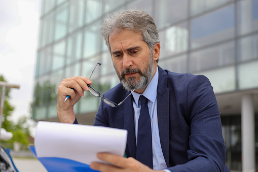 Caucasian businessman working with paper work and tablet computer at office