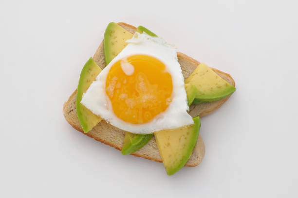 istock Avocado toast with fried egg on white desk. 1278658455