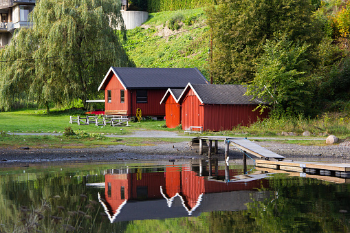 Two red houses near the lake.