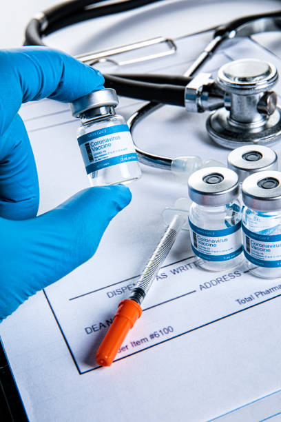istock Blue Glove holding Coronavirus vaccine vial on white background 1278659392