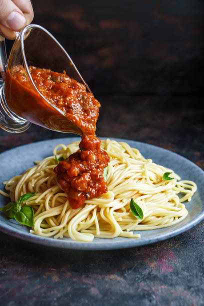 istock Pouring spaghetti with tomato sauce 1278662488