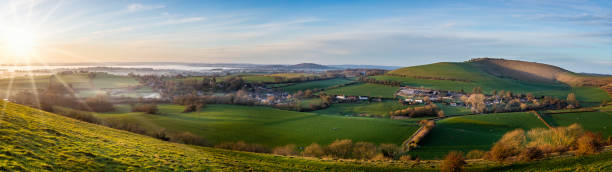 Panoramic View from hilltop of sun setting im misty valley in Dorset