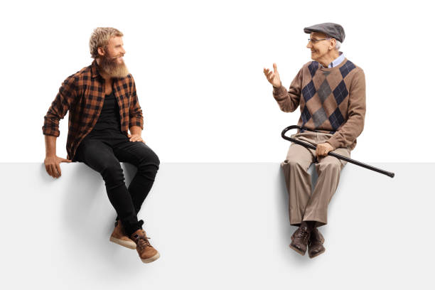 istock Elderly man talking to a bearded guy and sitting on a white panel 1278664260