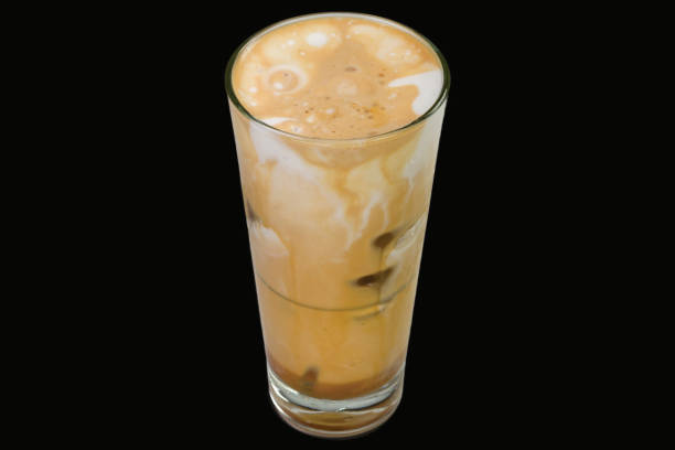 cold cappuccino Delicious freddo Cappuccino with ice cubes in a glass, isolated on black background freddo cappuccino stock pictures, royalty-free photos & images