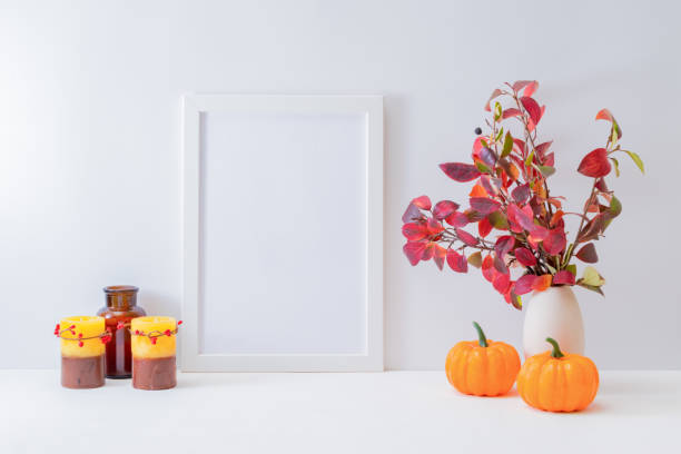 istock Home interior with decor elements. Mockup with a white frame, colorful autumn leaves in a vase on a light background 1278667700