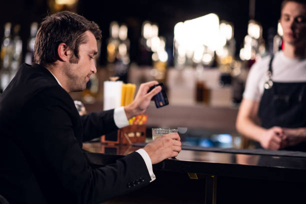 istock a man holds a plastic card, pays for a cocktail in a bar 1278668844