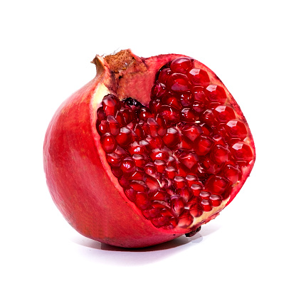 Ripe, red pomegranate cut in half, on a white background. Isolated object.