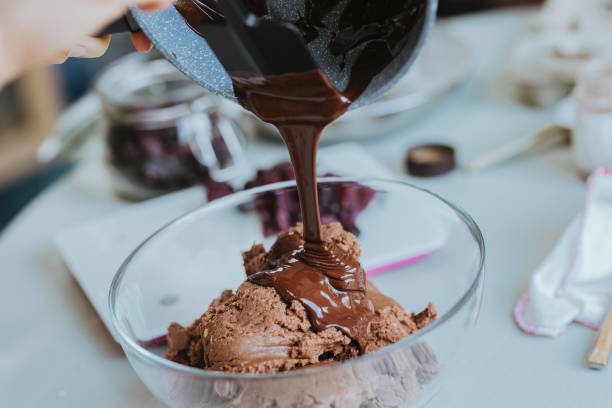 istock Anonymous Woman Pouring Melted Chocolate onto Cookie Dough 1278671147