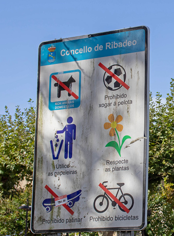 Ribadeo, Spain - October 4, 2020:Warning signs at the Plaza de Espana square in the Ribadeo city center, Lugo, Galicia, Spain. Messages in gallego language.