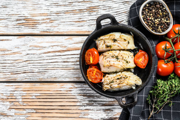 istock Grilled pollock or coalfish fillets in a pan. White background. Top view. Copy space 1278673295