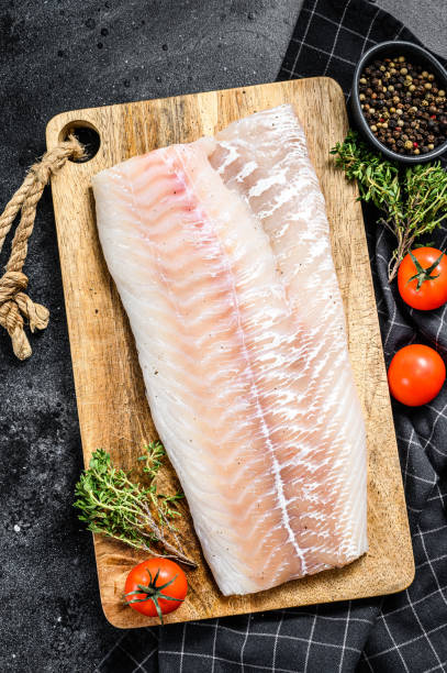 istock Fresh Raw Cod loin fillet with thyme.  Black background. Top view 1278673343