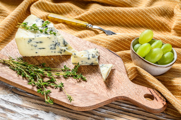istock Triangle of blue cheese with grapes. White wooden background. Top view. Copy space 1278674400