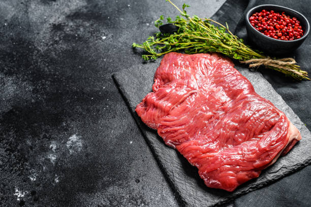 istock Raw outside skirt steak, marbled meat. Black background. Top view. Copy space 1278675320