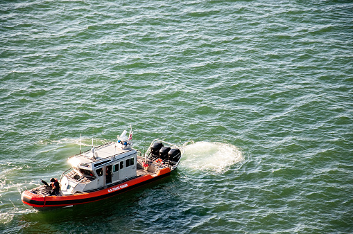 Red and white US coast guard boat in open water