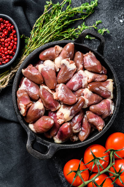 istock Raw chicken hearts in a pan. Organic offal. Black background. Top view 1278679792