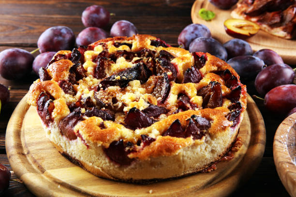 istock Rustic plum cake on wooden background with plums around. 1278682267