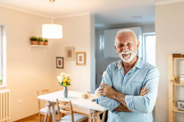 istock Senior man looking at camera and smiling in living room 1278684939