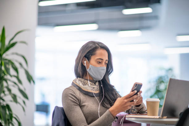 istock Young business woman in face mask working 1278686413