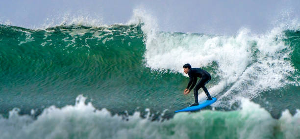 Panoramic shot of surfer braving the waves