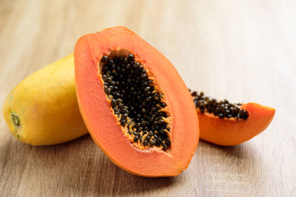 istock Half ripe papaya fruit on wooden background 1278693304