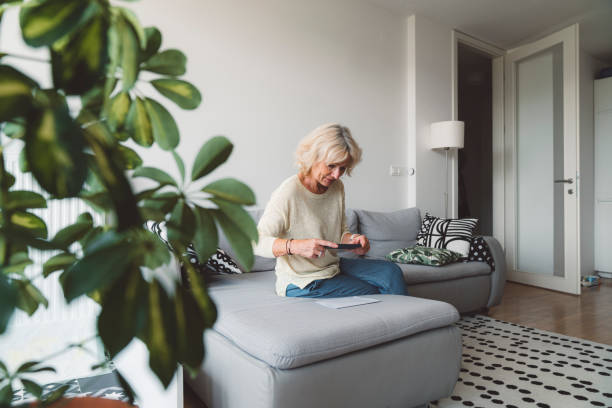 istock Senior woman paying a bill with her phone 1278694845