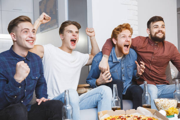 mężczyźni oglądający sport w telewizji razem w domu krzycząc wesoły - sitting 20s adult american football zdjęcia i obrazy z banku zdjęć