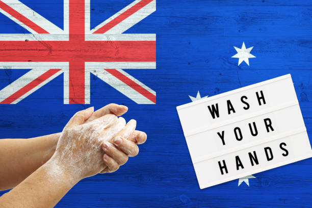 istock Australia flag background on wooden surface. Minimal wash your hands board with minimal international hygiene concept hand detail. 1278695437
