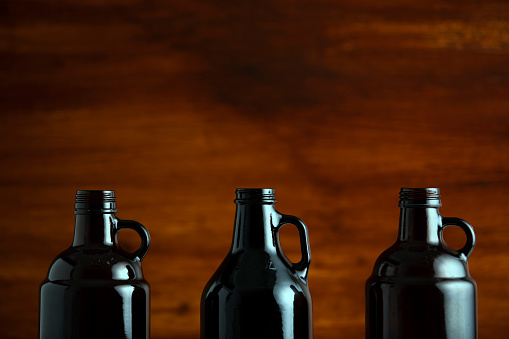beer growler bottles for craft beer with white space for a copy over a wood background