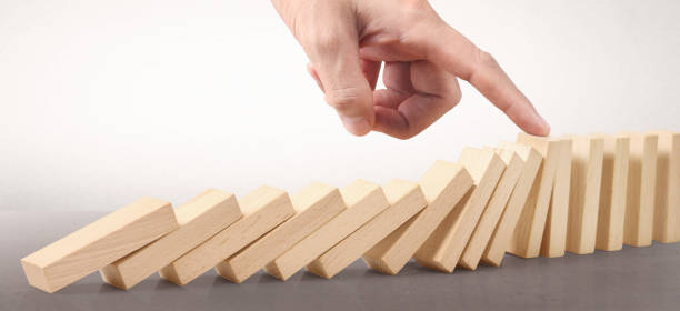 istock Domino wooden falling over effect stopped by unique 1278706021