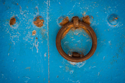 Old blue door with rusty handle