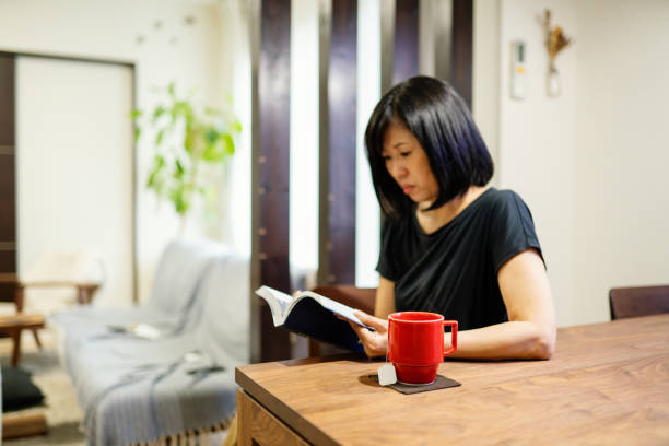 istock Woman reading a book with a cup of coffee 1278711573