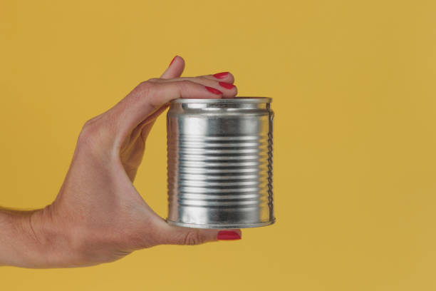 istock Female hand holding a can on a yellow background 1278714190