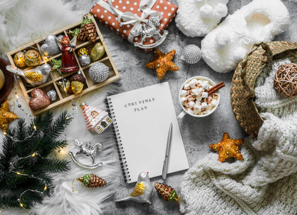 christmas cozy home background. christmas planning notepad, toys, hot chocolate, slippers, basket with knitted blanket on a gray background, top view - milk old fashioned retro revival still life imagens e fotografias de stock