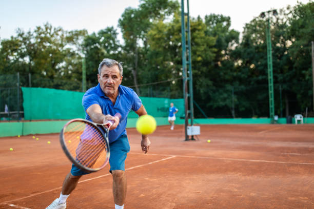 senior tennisspieler genießen tennis-match auf tennisplatz - tennis active seniors healthy lifestyle senior men stock-fotos und bilder