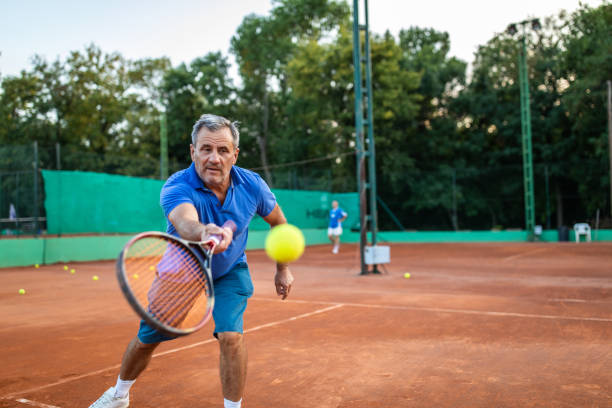 senior tennis player enjoying tennis match on tennis court - volleying sport summer men imagens e fotografias de stock