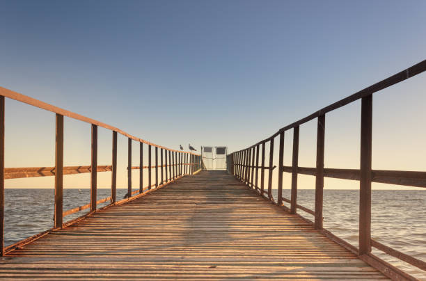 istock Old wooden pier with railings at sunset. 1278732368