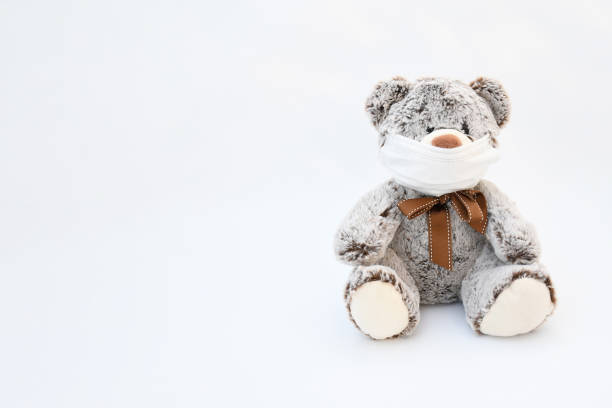 istock Object, brown gray liitle bear doll wearing a protective medical mask on white background. Infor for  second wave of coronavirus infect ,new normal 's life concept. 1278733238