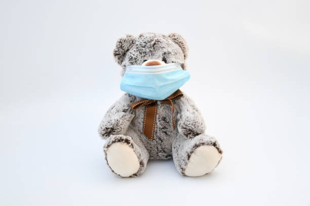istock Object, brown gray liitle bear doll wearing a protective medical mask on white background. Infor for  second wave of coronavirus infect ,new normal 's life concept. 1278733286