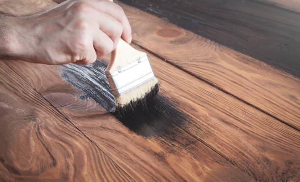 istock Man painting wood with a brush. 1278734614