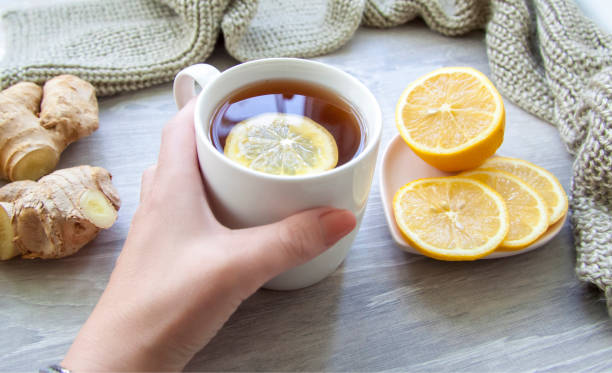 istock Ginger tea with lemon. A Cup of tea is held by a woman's hand. 1278736319