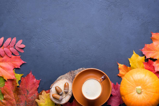 istock Autumn still life composition with coffee, pumpkin and bright leaves on dark concrete background. 1278737421