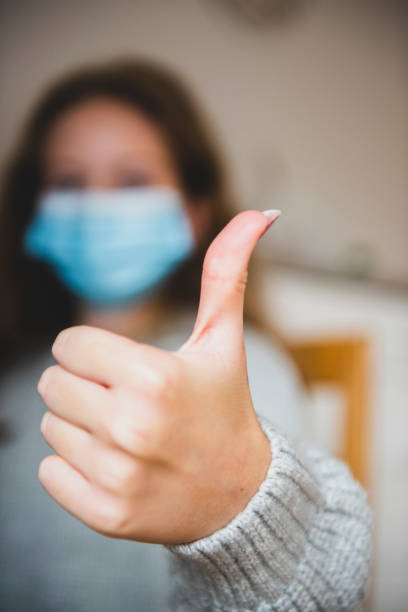 istock Student with mask due covid-19 gesturing thumbs up at home 1278738541