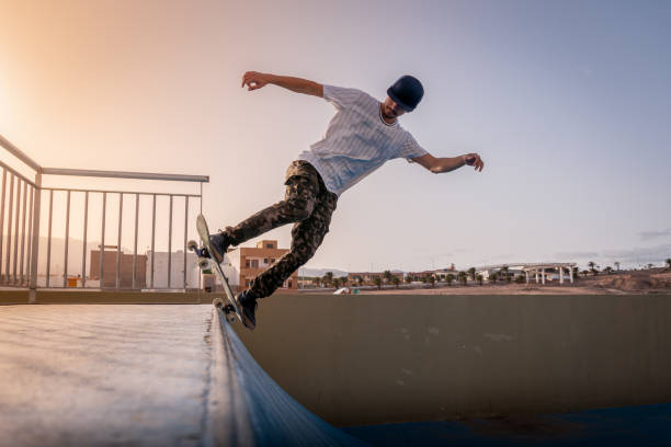 istock young skateboarder doing a backside 5-0 on ramp. Behind him, the sun is falling 1278738641