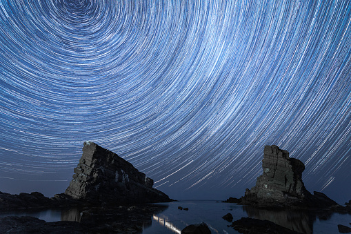 Landscape and astrophotography - rock formations - ships and night sky with star trails, Sinemorets, Bulgaria