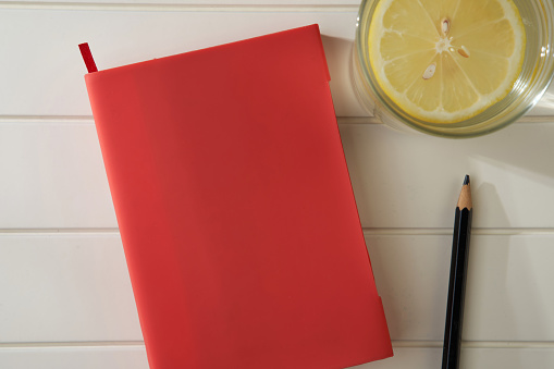 red note book on the white table